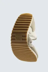 Zapatilla deportiva estilo barefoot, color marrón, con diseño de puntera ancha y redondeada. Confeccionada en una combinación de materiales textiles y detalles en serraje. Cuenta con suela fina de goma flexible y cordones en color crema.