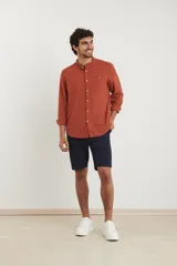 Camisa de cuello mao y manga larga, confeccionada en una mezcla de lino y algodón. Presenta un diseño de corte recto con botones en tono natural y un bolsillo pequeño en el pecho.