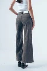 Jean de corte wide leg y tiro alto, color negro, con paneles laterales en el ruedo que aportan mayor amplitud y movimiento.