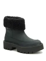 Bota de caña corta en color negro, confeccionada en nubuck con cuello de peluche sintético. Presenta una suela de plataforma dentada de goma, brindando un estilo robusto y moderno.
