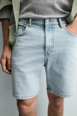 Bermuda de jean con corte regular fit, confeccionada en denim de algodón con elasticidad. Presenta diseño de cinco bolsillos, efecto lavado y cierre frontal con cremallera y botón.