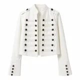 Chaqueta blanca de estilo militar con cuello mao, cierre frontal con múltiples botones metálicos oscuros y detalles de cordones horizontales. Presenta hombreras decorativas y puños acampanados con botones.