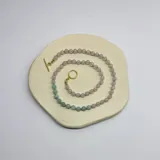 Collar de piedras naturales compuesto por cuentas de cuarzo rosa y larimar de 6 mm, con cierre de barra y argolla en baño de oro.