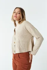 Cardigan de tejido de punto color gris melange, con escote en V, cierre frontal con botones y bolsillos tipo cartera. Presenta un diseño de corte recto y mangas largas.