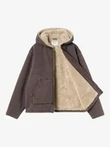 Campera con capucha Carhartt WIP modelo Mitch, color marrón oscuro, confeccionada en lona de algodón de peso medio con forro interno de corderito sintético. Cuenta con cierre frontal bidireccional, bolsillos frontales tipo parche y etiqueta cuadrada tejida con el logo de la marca.