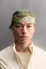Bandana cuadrada confeccionada en tejido ligero de mezcla de ramio y algodón, con diseño de patchwork que combina paneles con estampados florales y paisley en tonos amarillo, mostaza y verde militar.