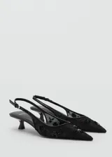 Zapato tipo slingback color negro con punta fina y tacón kitten de 5 cm. Confeccionado en tejido de malla con bordados de lentejuelas y cierre de tira con hebilla ajustable.