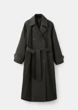 Chaqueta estilo gabardina larga en color gris oscuro, con doble botonadura frontal, solapas clásicas, bolsillos y trabillas ajustables en los puños.