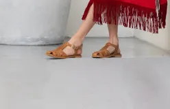 Sandalias chatas de cuero color camel, con múltiples tiras y hebilla lateral ajustable.