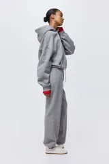 Pantalón deportivo de tiro alto confeccionado en felpa de mezcla de algodón con interior cepillado. Presenta cintura elástica con cordón de ajuste, bolsillos laterales al bies y puños elásticos en los bajos.