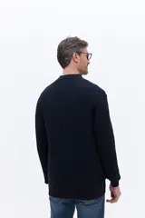 Buzo de tejido acanalado con cuello alto y apertura frontal con cierre, de calce cómodo y estructura limpia.