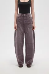 Pantalon de jean estilo barrel con tiro alto, diseño de paneles reforzados en las piernas y costuras visibles con remaches metálicos.