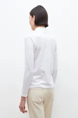 Remera de manga larga color blanco, con cuello alto con volados.