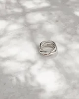 Anillo de diseño artesanal con estructura entrelazada de líneas irregulares y acabado orgánico. Pieza ajustable fabricada en metales nobles.