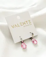 Par de aros colgantes plateados con dije de cristal rosado en forma de lágrima.