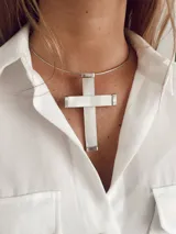 Gargantilla plateada con dije de cruz grande de nácar.