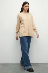 Polera negra de manga larga con puños elastizados, cuello alto y sutiles aberturas en los laterales.