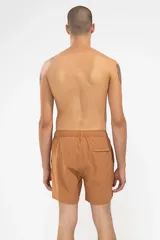 Short de baño color arcilla con bordado de enredadera en la pierna, cintura elástica con cordón ajustable, bolsillos laterales y bolsillo trasero con cierre.