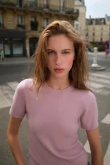 Jersey de punto color rosado claro, con cuello redondo y manga corta. Presenta una textura suave y un acabado ligeramente jaspeado.