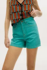 Short de denim tiro alto con corte recto y costuras a contratono. Cuenta con cierre frontal con botón metálico y bolsillos laterales.