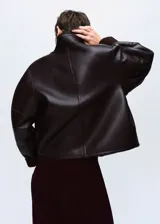 Chaqueta reversible de corte recto y diseño oversize, confeccionada en efecto cuero con interior de borreguito. Presenta cuello alto, cierre frontal con botones y mangas largas.