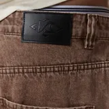 Pantalón de jean estilo skater, color marrón, de corte holgado y diseño clásico de cinco bolsillos.