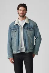 Campera de jean celeste Levi's modelo Type 3 Sherpa con cuello de corderito color crema, bolsillos frontales con solapa y cierre de botones metálicos.