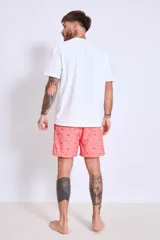 Short de baño de corte clásico en color celeste claro con estampado de pequeñas aves en tono oscuro. Cuenta con cintura elástica y un pequeño parche decorativo en el ruedo.