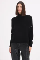 Sweater de cuello alto tipo polera, color negro, con detalle de pespuntes decorativos en color blanco en las mangas y laterales.