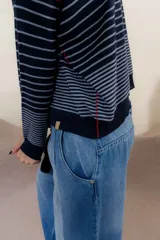 Sweater color crema con rayas horizontales y mangas largas.