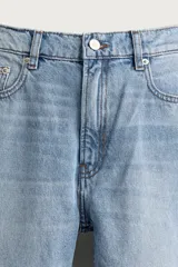 Pantalón de jean corte slim fit, color azul oscuro, con diseño de cinco bolsillos, tiro medio y cierre frontal con cremallera y botón.