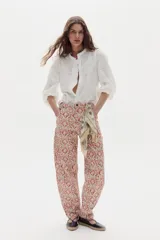 Pantalón de jean color blanco marfil, con tiro medio, corte barrel relajado y bolsillos frontales y traseros.
