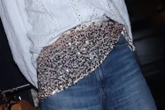 Pañuelo versátil confeccionado en tela de fiesta totalmente cubierta de lentejuelas azul marino, diseñado para usar como faja, bufanda, accesorio para el cabello u otras combinaciones.