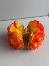 Accesorio para el pelo con diseño de flor grande en color fucsia, confeccionado en tela con pétalos en capas.