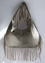Cartera de hombro color dorado con textura símil cocodrilo y flecos colgantes en los bordes y las asas, de la marca Carolina de Cupto.