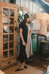 Vestido largo de punto acanalado en color negro, con escote en V, mangas cortas y aberturas laterales en el ruedo.