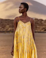 Vestido largo y fluido de seda lúrex en color amarillo, con estampado inspirado en pañuelo, escote en V, tirantes ajustables y bajo con volante.