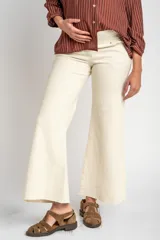 Pantalón de jean color beige, de corte wide leg con botamanga desflecada y tiro medio, diseñado especialmente para maternidad.