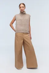 Chaleco de punto azul con cuello alto y diseño de trenzas.