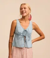 Blusa sin mangas confeccionada en jeans color celeste, con escote en V y ajuste con lazos en el frente.