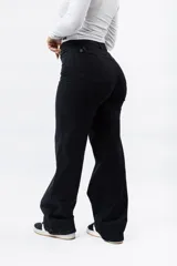 Pantalón wide leg color negro, con tiro alto y cierre de botón y cremallera.