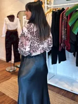 Falda midi de satén en color negro, con corte al bies y caída fluida que se ajusta suavemente a la silueta.