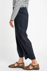 Pantalón ancho azul marino con cintura elástica, bolsillos laterales y detalle de botones en el tobillo.