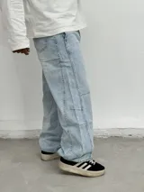 Jean de corte baggy y estilo wide leg en color azul claro con efecto lavado. Presenta costuras reforzadas en las piernas y un diseño holgado que aporta comodidad y un estilo urbano.