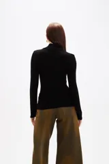 Polera de viscosa color negro, de corte ajustado al cuerpo, con cuello alto y mangas largas.