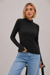 Polera negra de manga larga con cuello alto, confeccionada en tejido suave y elástico con calce al cuerpo.