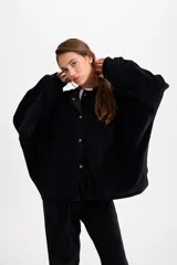 Campera de terciopelo color chocolate, con corte holgado, mangas murciélago y capucha desmontable. Presenta cierre frontal con botones a presión y bolsillos laterales.