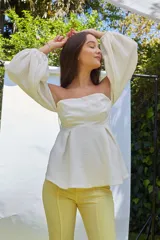 Blusa blanca strapless con mangas largas abullonadas.