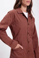 Enterito marrón de jean con cuello camisero, manga larga, cierre frontal con botones, bolsillos en el pecho y laterales.