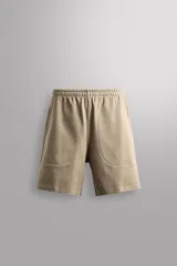 Short jogger de Zara Athleticz color beige, de corte relajado, confeccionado en tejido compacto de algodón. Cuenta con cintura elástica ajustable, bolsillos frontales y bolsillos traseros de parche.